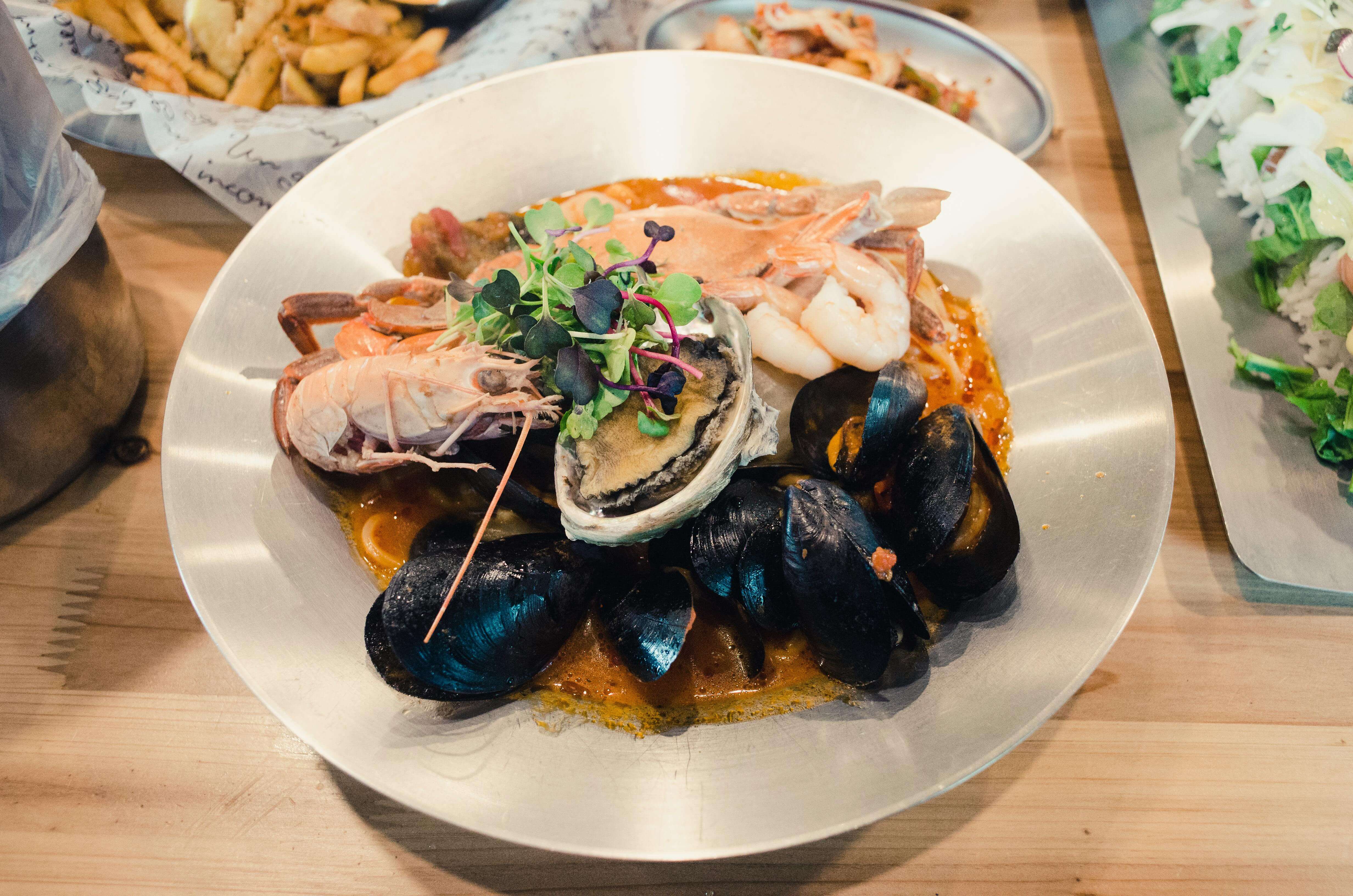a plat of lobsters and oysters on a table in a restaurant