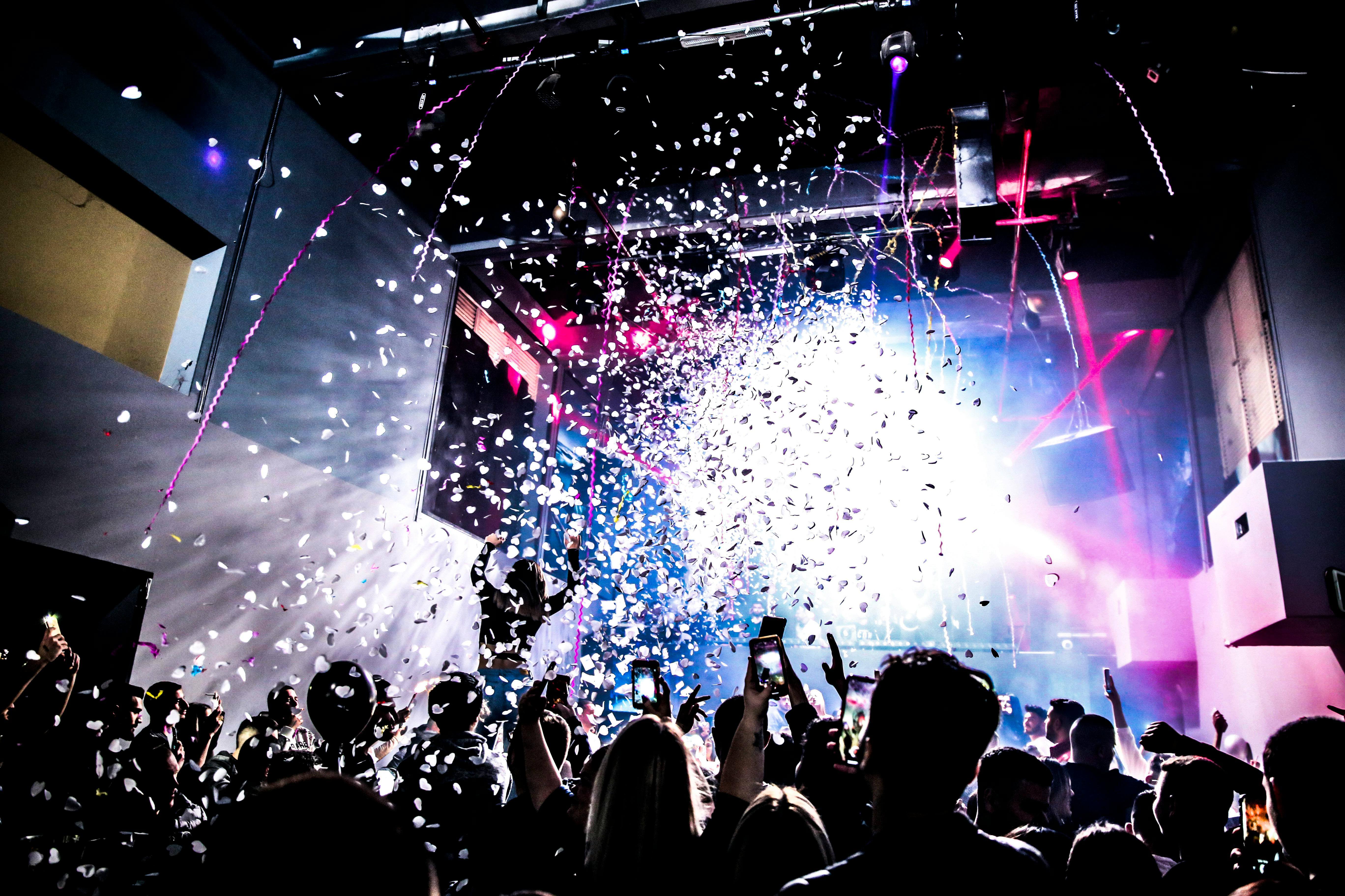 a crowd dancing under lights and confetti