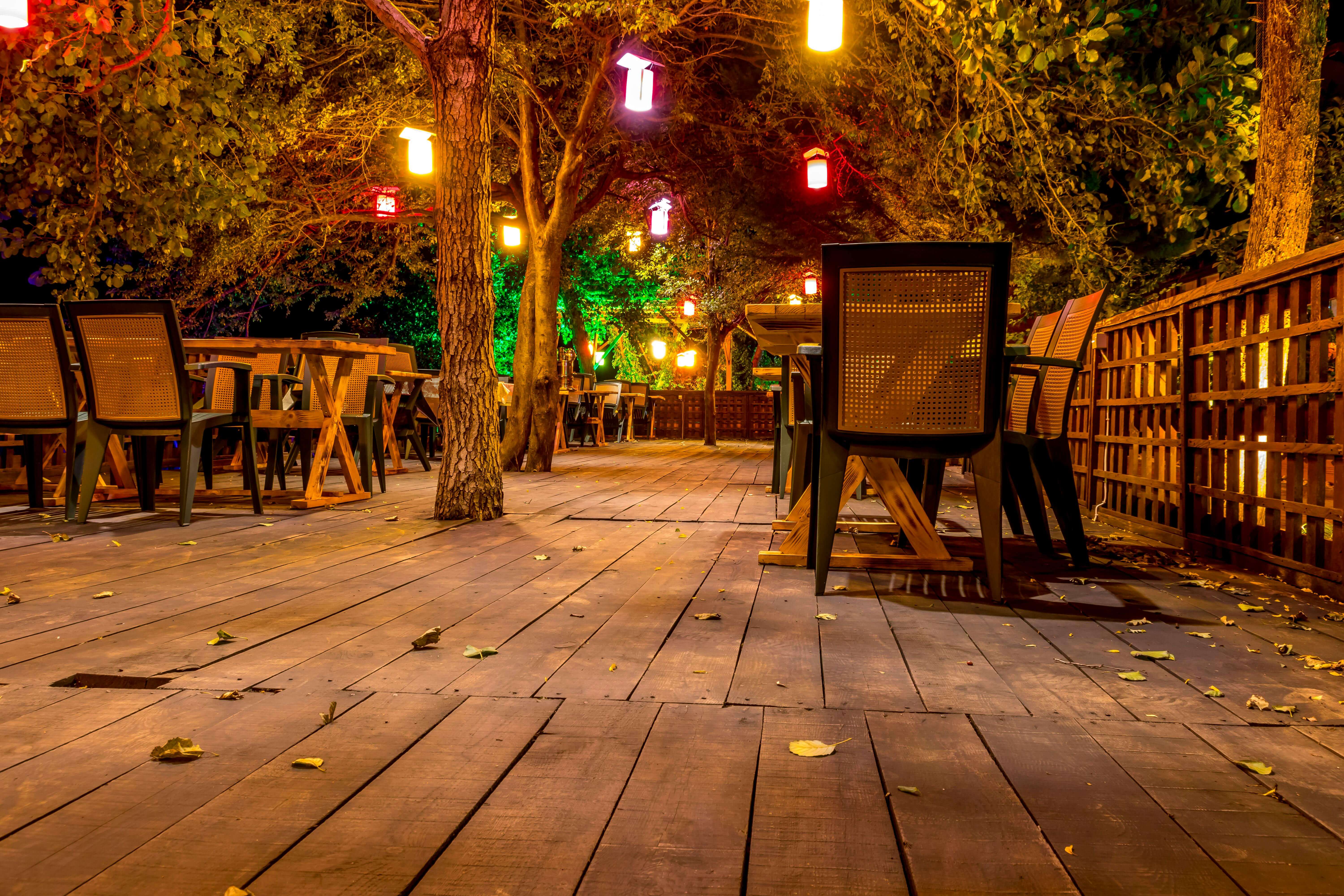 dining on the wooden terrace of a restaurant with mood lighting