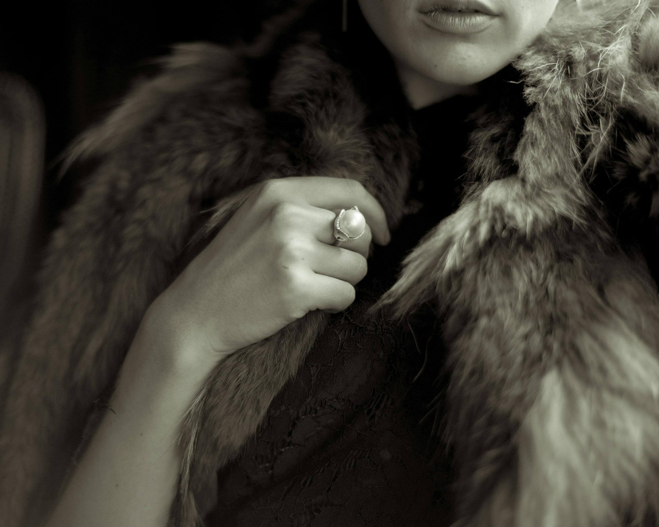 a classy woman in a fur coat wearing a ring