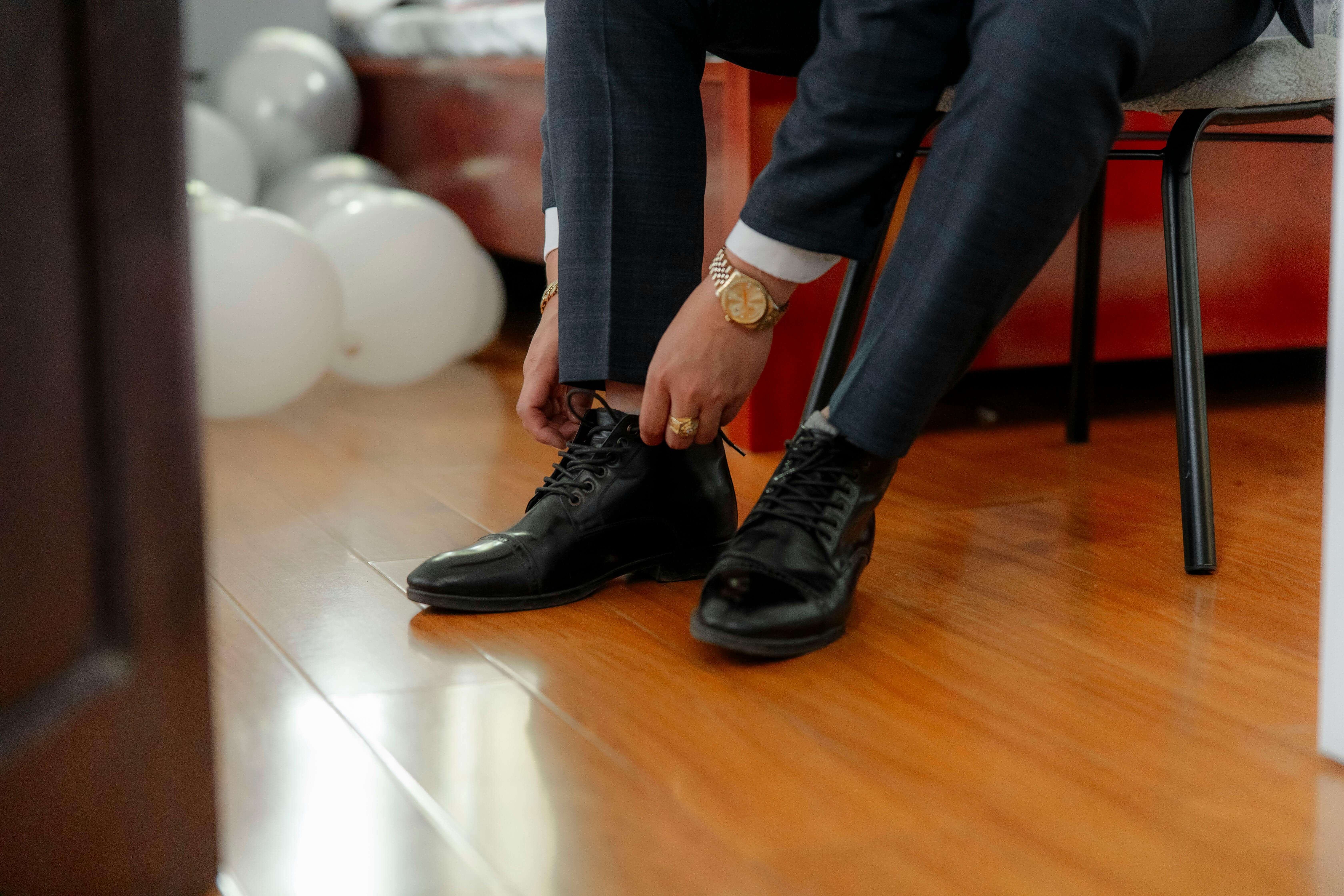 a man in a suit putting on smart shoes