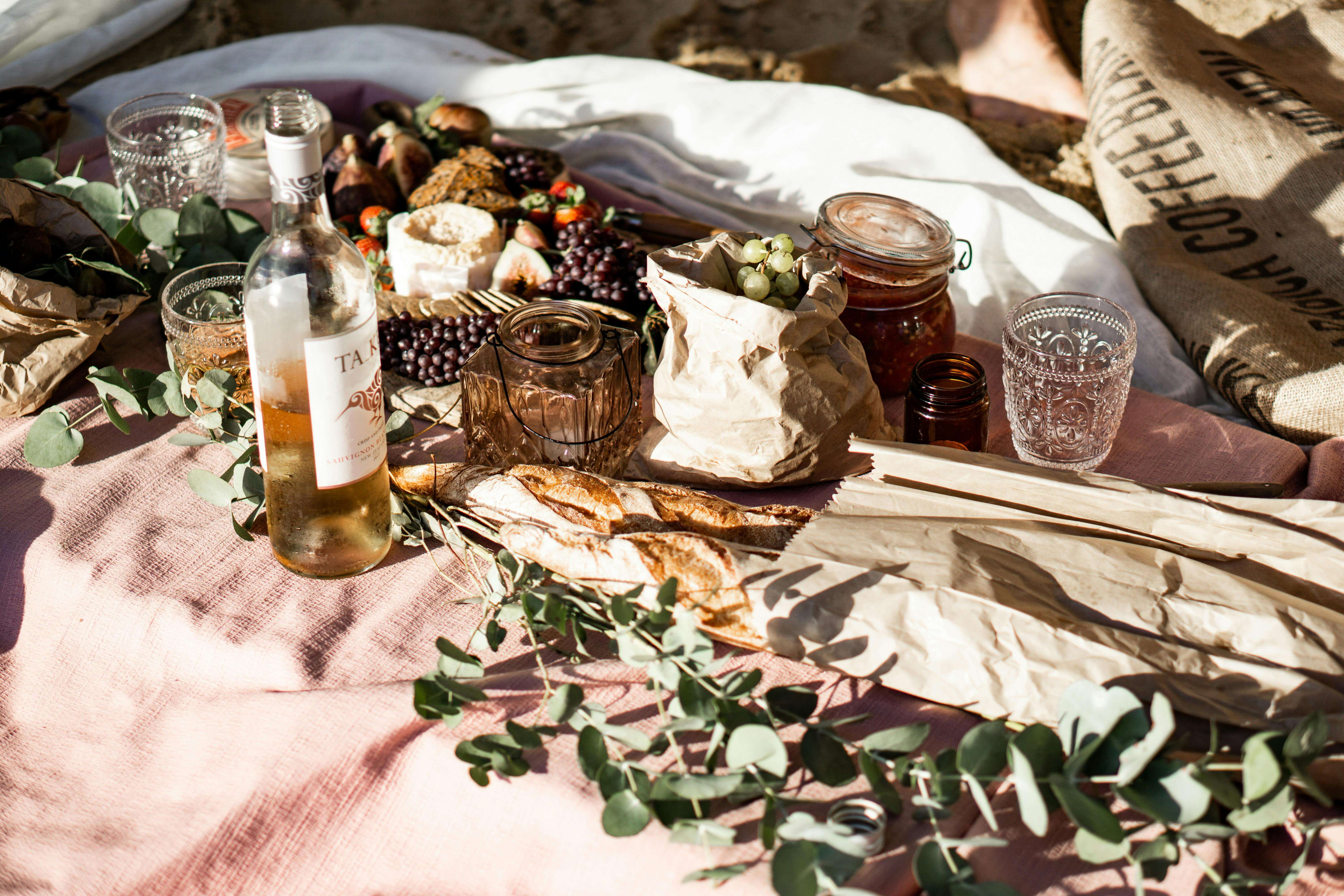 a selection of gourmet foods on a picnic blanket