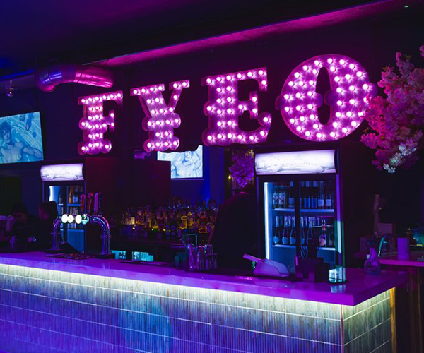 Neon purple bar FYEO sign for your eyes only interior